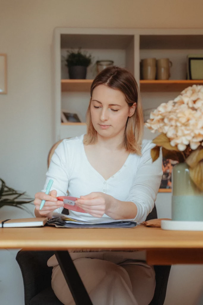 Hebamme Isabel Braun sitzt im Büro am Schreibtisch und koordiniert Kontaktanfragen zur individuellen Hebammenbetreuung.